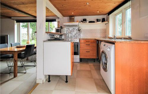 a kitchen with a washing machine and a table at Stunning Home In Löberöd With Kitchen in Löberöd