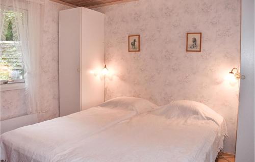 - une chambre avec un lit blanc et deux photos sur le mur dans l'établissement 2 Bedroom Beautiful Home In Vstra Torup, à Västra Torup