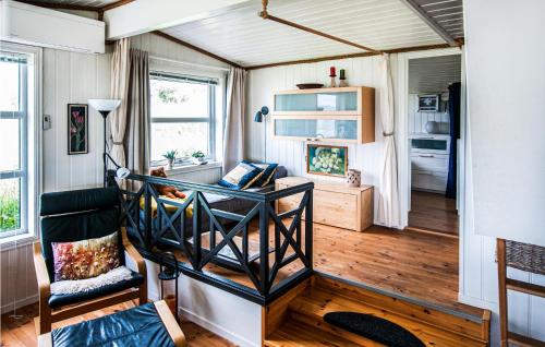 una habitación con sofá y silla en una casa pequeña en Nice Home In Malvik With Kitchen, en Malvik