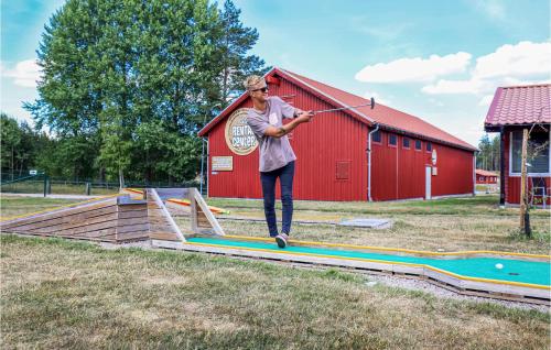 a woman jumping on a wooden ramp with a stick at Nice Home In Kosta With Wifi in Kosta