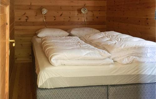 - duże białe łóżko w drewnianym pokoju w obiekcie Nice Home In Mandal With 3 Bedrooms And Wifi w mieście Mandal