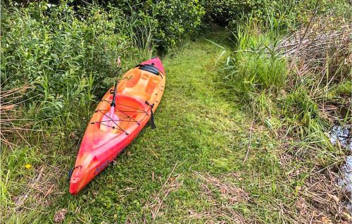 a red kayak sitting on the grass in a field at 3 Bedroom Stunning Home In Lekeryd in Lekeryd