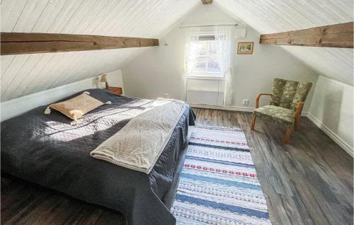 1 dormitorio con 1 cama y 1 silla en el ático en Lovely Home In Trans With Wifi, en Tranås