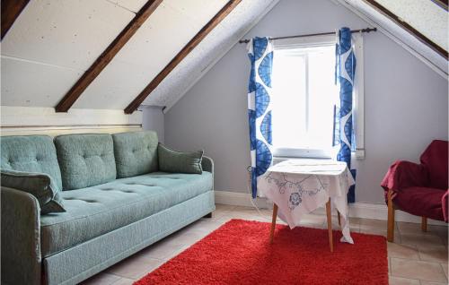 uma sala de estar com um sofá verde e um tapete vermelho em 2 Bedroom Beautiful Home In Sderkra em Söderåkra