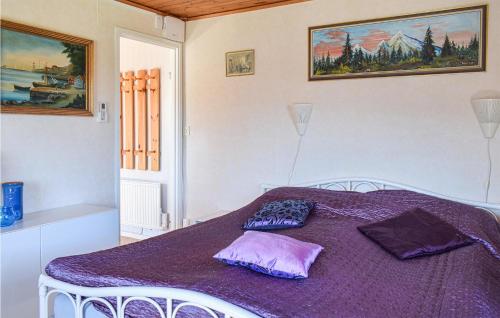 a bedroom with a purple bed with two pillows on it at 2 Bedroom Pet Friendly Home In Figeholm in Figeholm