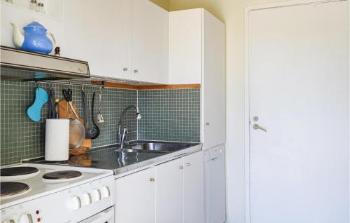 una cocina con armarios blancos y fregadero en Awesome Home In Hjlteby With Wifi en Hjälteby