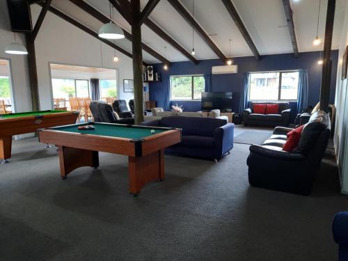 a living room with a pool table and couches at Manowhenua Lodge in National Park