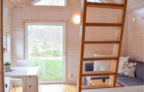 a tiny house with a ladder and a desk at Cozy Home In Hagby With Kitchen in Hagby
