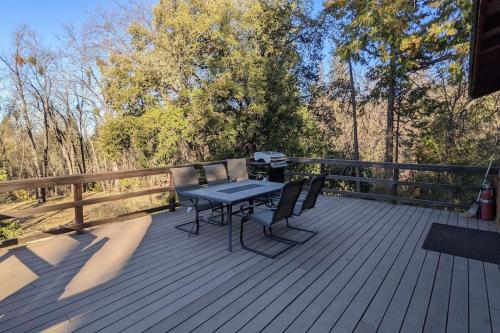 a patio with a table and chairs on a wooden deck at Gilmore Cabin in Miramonte