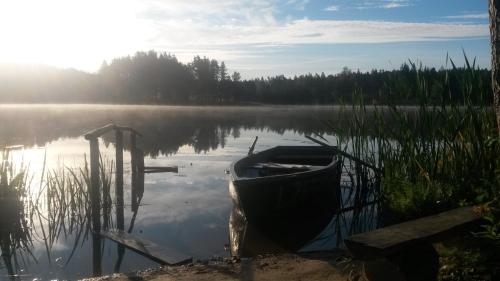 a boat sitting on the shore of a lake at Ezerkalni in Raiskums