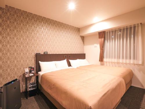 Postel nebo postele na pokoji v ubytování HOTEL LiVEMAX Shinyokohama