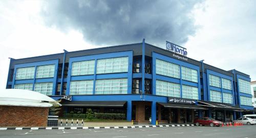 um edifício azul com um carro estacionado em frente em Athome Boutique Hotel em Bintulu