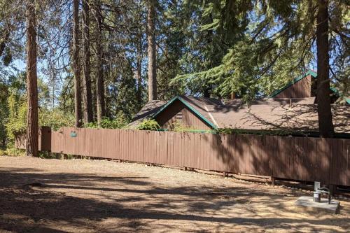 a fence in front of a house with trees at Pierce's Cabin in Miramonte