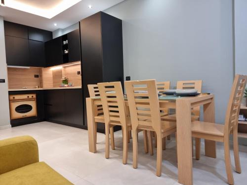 uma cozinha e sala de jantar com uma mesa de madeira e cadeiras em Holiday apartment near the sea em Durrës