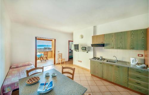 a kitchen and living room with a table and chairs at Bilo Sup in Isola Rossa