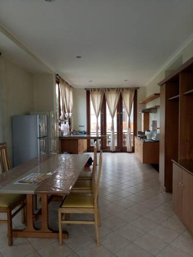 une grande cuisine avec une table et des chaises. dans l'établissement Luxury Villa Lembang Bandung (Villa Istana Bunga), à Lembang
