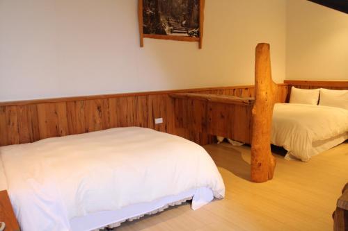 a bedroom with two beds and a wooden bed frame at Shangrila Leisure Farm in Dongshan