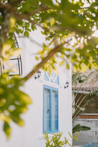 a blue window on the side of a white building at SANTORI Hoi An Homestay in Hoi An