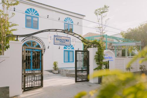 an entrance to a white building with blue doors at SANTORI Hoi An Homestay in Hoi An