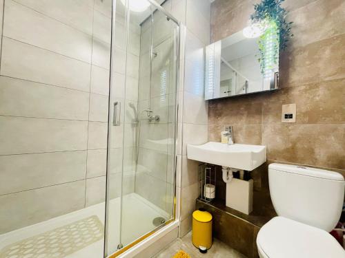a bathroom with a shower and a toilet and a sink at Park Street Apartment Luton by Hostaguest in Luton