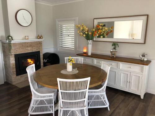 uma sala de jantar com uma mesa e cadeiras e uma lareira em Armara Views em Orange