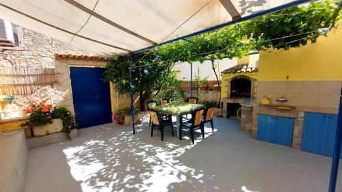 een patio met een tafel en stoelen in een keuken bij Apartment Nadi - 100 m from sea in Unije