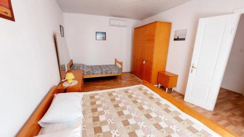 een slaapkamer met een bed en een deur met een tapijt bij Apartment Nadi - 100 m from sea in Unije