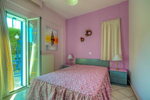 a bedroom with a bed with purple walls and a window at Cozy Apartment Amoudara Heraklion Crera-4 in Ayía Marína