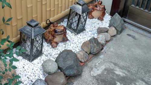 a garden with rocks and lanterns on a patio at Kyoto Osaka SUMIREYA in Takatuki