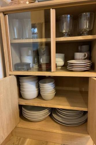 a cabinet filled with plates and bowls and dishes at Kyoto Osaka SUMIREYA in Takatuki