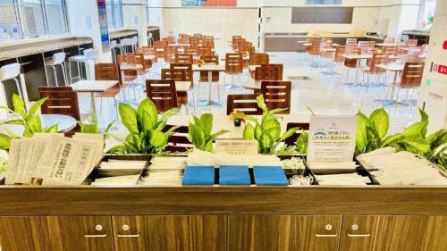 a long table with tables and chairs in a room at Toyoko Inn Nagoya Kanayama in Nagoya