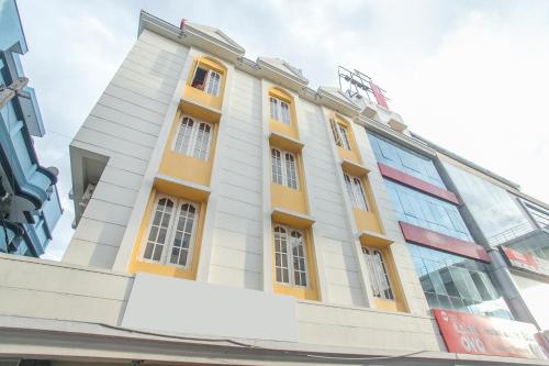 a building with yellow and white at Hotel O ABHIMAANI COMFORTS in Bengaluru
