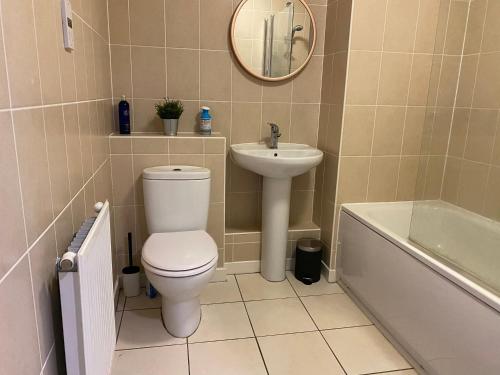 a bathroom with a toilet and a sink and a tub at Marston House in Marston Green