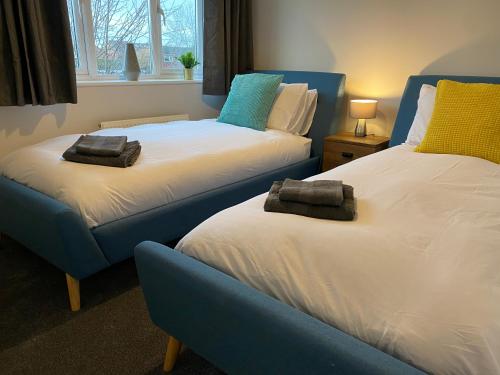 a bedroom with two beds with towels on them at Marston House in Marston Green