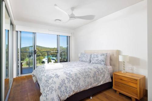 a bedroom with a bed and a large window at 506 The Shoal in Shoal Bay