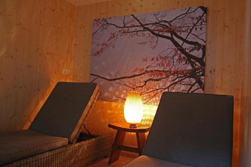 a living room with a chair and a lamp at Mühlradl Apartments Gosau in Gosau