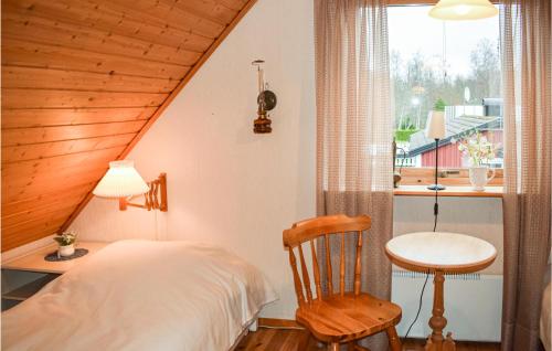 een slaapkamer met een bed, een stoel en een raam bij Amazing Home In Ljungby With Lake View in Bolmsö