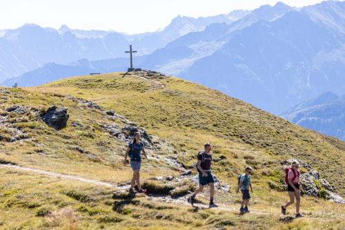 a group of people walking on a hill with a cross at Apartment Rauch in Zell am Ziller