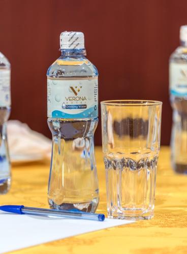 a bottle of water and a glass on a table at Verona Hotel and Conference Center in Ruiru