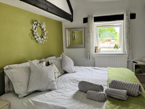 a bedroom with a large white bed with pillows on it at Swift Cottage in Liskeard