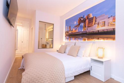 Un dormitorio con una cama blanca y una pintura en la pared en Bilbao Henao Park de Bilbao Suites, en pleno centro con garaje directo en Bilbao