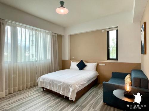 a hotel room with a bed and a couch at 趣日民宿-Cheatday Villa 親子 麻將 烤肉 廚房 獨棟 in Ji'an