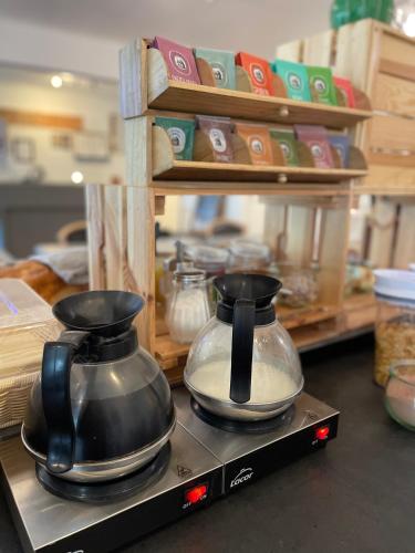 2 casseroles et poêles assises au-dessus d'une étagère dans l'établissement Tourhôtel, à Béthune