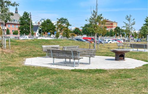 a park with benches and a picnic table in a field at Awesome Apartment In Ystad in Ystad