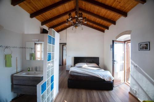 a bedroom with a bed and a bathroom with a sink at Villa Belvedere, Upper Qeparo in Himare