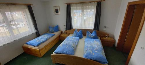 a bedroom with two beds with blue pillows at Haus Jirka in Nauders