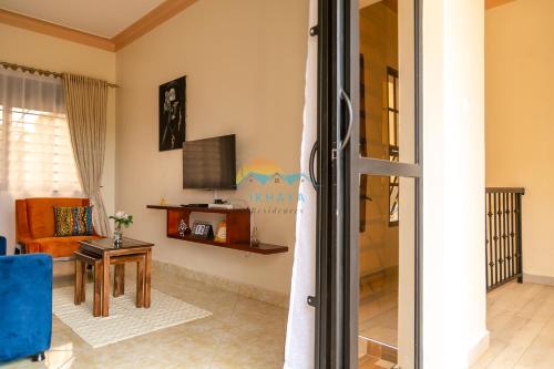 a living room with a television and a table at iKHAYA-Nsambya in Kampala