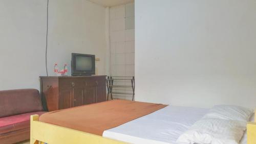 a bedroom with a bed and a tv on a dresser at Hotel Jaya Kusuma near Candi Prambanan Mitra RedDoorz in Prambanan