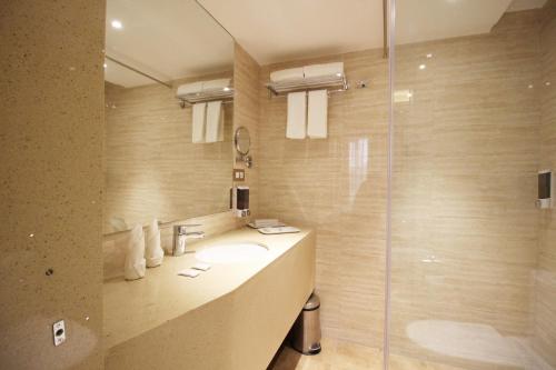 a bathroom with a sink and a shower at Hotel Jagadish International-Sankey Road in Bengaluru