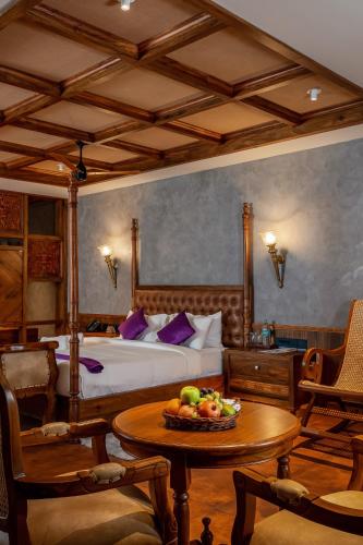 a bedroom with a bed and a table with a bowl of fruit at Malabar Ocean Front Resort And Spa, Bekal in Nīleshwar